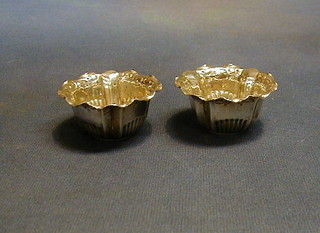 A pair of circular Victorian embossed silver salts, London 1897