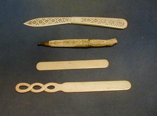 A pierced ivory folding paper knife, a steel bladed knife with ivory handle and scabbard the hilt decorated a dogs head and 2 other ivory paper knives