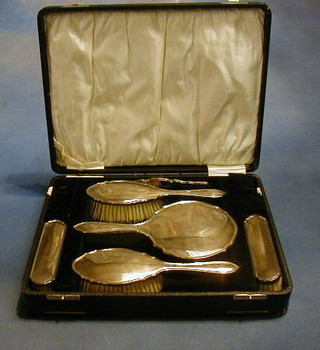 An Art Deco 5 piece silver backed dressing table set comprising 2 clothes brushes, 2 hair brushes and a hand mirror, Birmingham 1931, cased