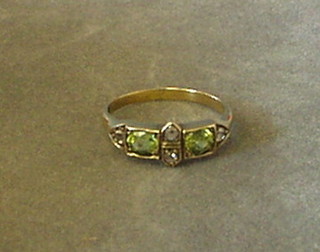 A gold dress ring set 2 circular cut peridots and 4 diamonds