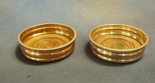 A pair of circular silver plated wine coasters with gadrooned borders