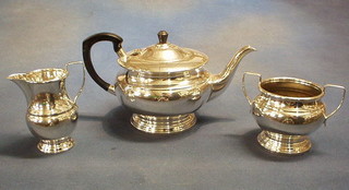 A circular 3 piece silver plated tea service with teapot, twin handled sugar bowl and cream jug