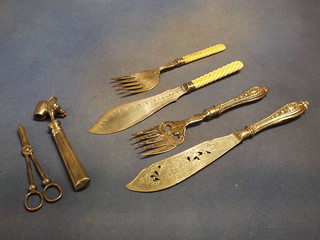 2 pairs of silver plated fish servers, a pair of silver plated grape scissors, a ham bone clamp