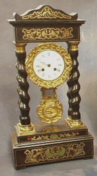 A 19th Century Empire mantel clock with enamelled dial and Roman numerals supported by 4 spiral turned columns, inlaid brass throughout