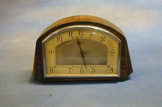 A 1930's 8 day bedroom clock with arched dial and Arabic numerals contained in arched oak case