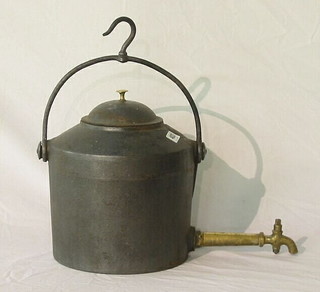 An iron tea kettle with brass spicket