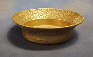 A circular embossed brass bowl 13"