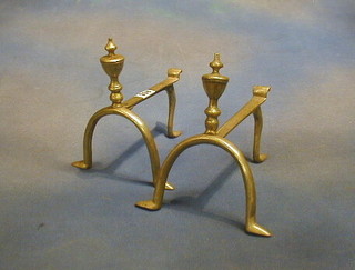 A pair of brass fire dogs