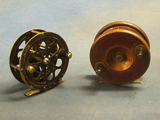 A wooden and brass fishing reel and a pierced metal Pflueger Sal-Trout no. 155 fishing reel