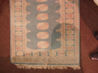 A contemporary turquoise  ground Bokhara rug with 14 octagons to the centre within multi row borders 71" x 33"