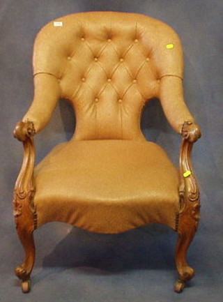 A Victorian carved walnutwood open arm chair upholstered buttoned brown rexine