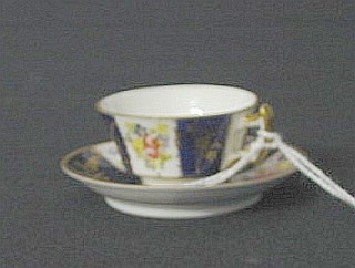 A Royal Crown Derby miniature cup and saucer, the cup marked VI and the saucer with 4 dots and impressed 10-01