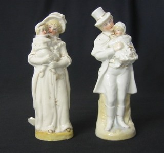A pair of 19th Century porcelain figures of lady and gentleman holding children 7"