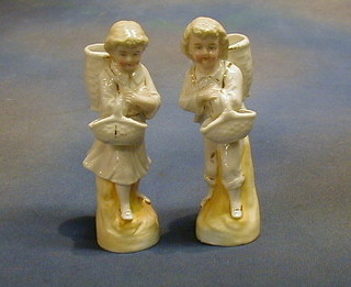 A pair of 19th Century Continental porcelain match holders in the form of children with panniers 7"