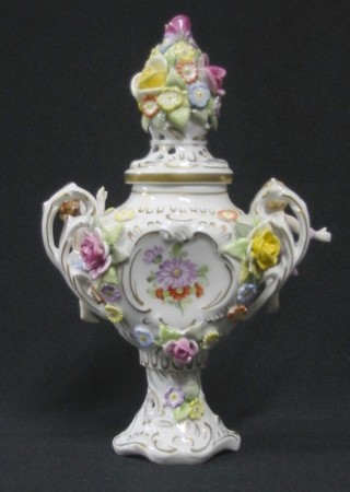 A Dresden style twin handled urn and cover with floral encrusted and cherub decoration 9"