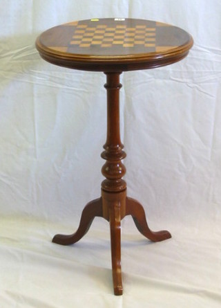 A 19th Century circular inlaid mahogany games table, the top inlaid a chessboard, raised on a turned column and tripod supports 19"