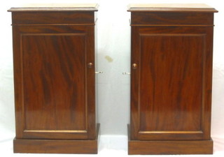 A pair of 19th Century mahogany pedestal bedside cabinets enclosed by panelled doors, 17"