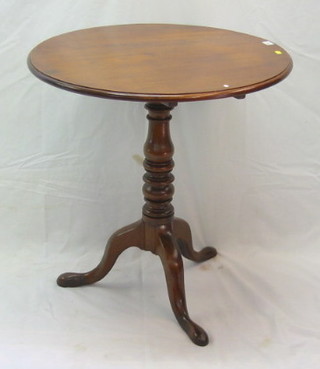 A 19th Century circular mahogany tea table, raised on a turned oak tripod column 28"