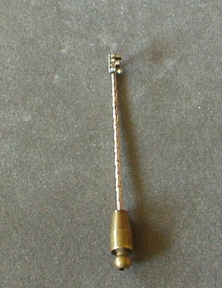 A gold and diamond stick pin in the form of  a letter E