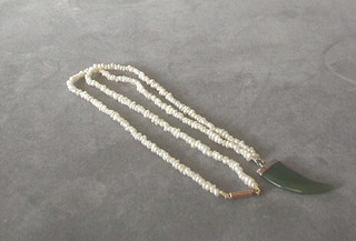 A string of seed pearls hung a jade coloured pendant