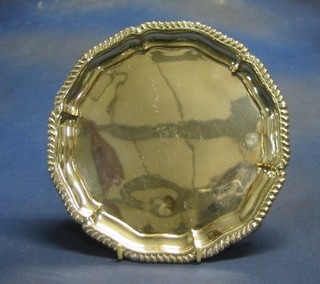 A  circular silver plated salver with bracketed border, raised on 3 panel supports 8"