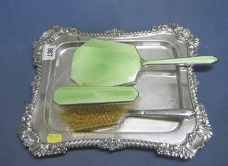 A rectangular silver plated bread border holder and a 3 piece chromium plated and enamelled dressing table set