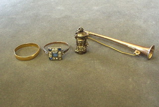 A 22ct gold wedding band (mishapen), a silver ring set blue and white stones, a silver charm in the form of a pillar box and a gilt metal hunting horn stock pin