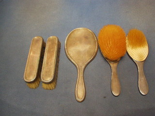 A silver backed 5 piece dressing table set with hand mirror, 2 hair brushes and 2 clothes brushes,