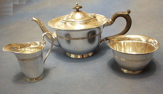 A circular 3 piece silver plated tea service with teapot, sugar bowl and cream jug