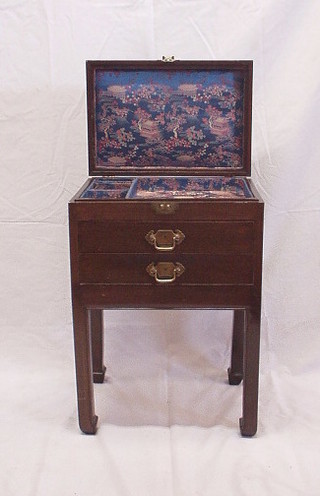 An Eastern hardwood jewellery cabinet with hinged lid, the base fitted 2 long drawers, raised on square supports and with brass carrying handles to the sides 17"