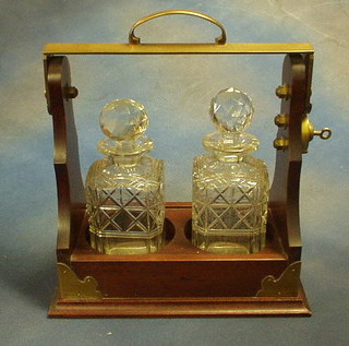 A mahogany and silver plated 2 bottle tantalus frame and 2 cut glass spirit decanters