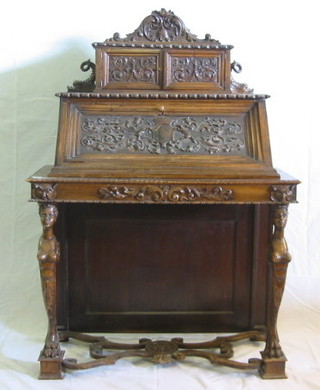 A 19th Century Italian carved walnutwood bureau, the upper section fitted a cabinet enclosed by panelled doors, the base with fall front carved a coat of arms, supported by 2 figures of Nubian women raised on hoof supports with X framed wavy stretcher, 41"