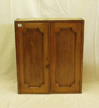 A 19th Century mahogany hanging cabinet, fitted shelves enclosed by panelled doors, 24"