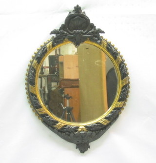 A 19th Century circular plate wall mirror contained in a black and gilt carved wooden frame 17"