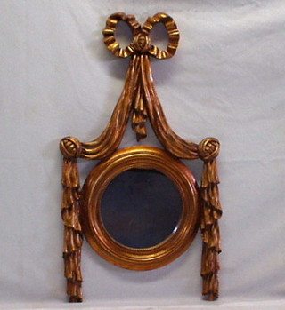 A circular Regency style plate mirror contained in a gilt frame surmounted by swags