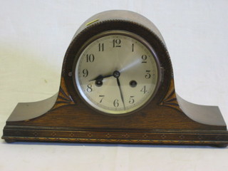 A striking mantel clock contained in an oak Admiral's hat shaped case