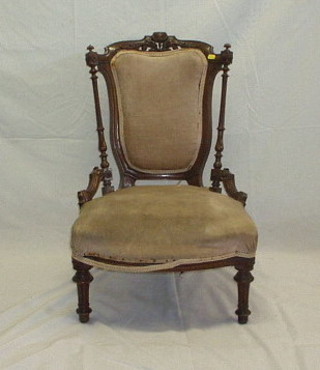 A Victorian carved walnutwood show frame nursing chair, on turned and fluted supports