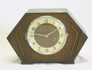 A 1930's 8 day striking mantel clock with silvered chapter ring contained in an oak lozenge shaped case