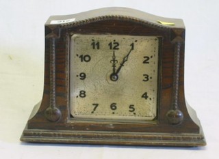 A 1930's 8 day mantel clock with square silvered dial contained in an arched oak case (f) and a 1950's mantel in an arched walnutwood case by West Clox