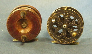 A wooden and brass fishing reel and a pierced metal Pflueger Sal-Trout no. 155 fishing reel