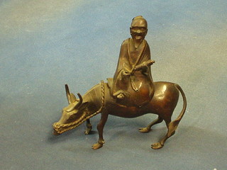 An Eastern bronze figure of a cow with seated sage, 8"