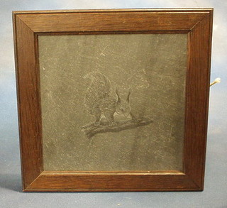 An etched section of slate decorated a squirrel contained in an oak frame 12"