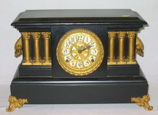 An American 8 day striking mantel clock contained in a wooden, black and gilt painted architectural case