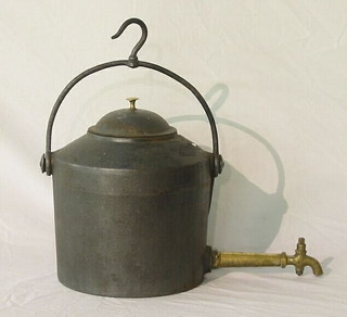 An iron tea kettle with brass spicket