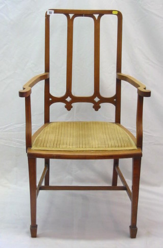 An Edwardian inlaid mahogany open arm stick and rail back carver chair, on square tapering supports and spade feet