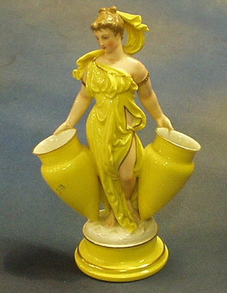 A 19th Century Continental porcelain table centre piece in the form of a classical lady supporting 2 amphoras 11" (f)