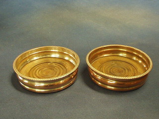 A pair of circular silver plated wine coasters with gadrooned borders