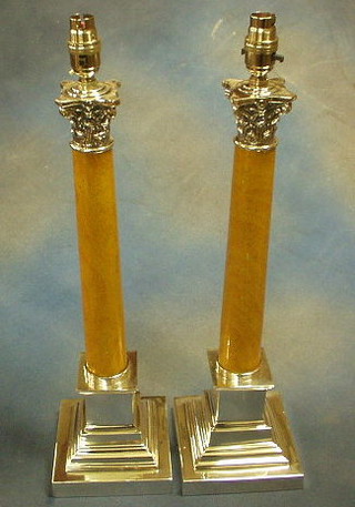A pair of stepped silver plated and simulated marble table lamps with Corinthian capitals