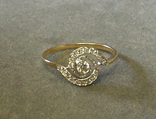 A lady's gold dress ring set a central diamond supported b 2 swirls set numerous diamonds