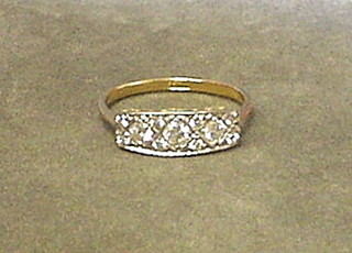 A lady's gold dress ring set 3 diamonds surrounded by numerous diamonds (approx 0.40)